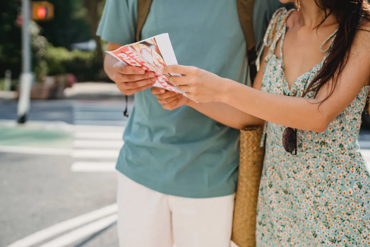 A couple holding a brochure for a tourist attraction