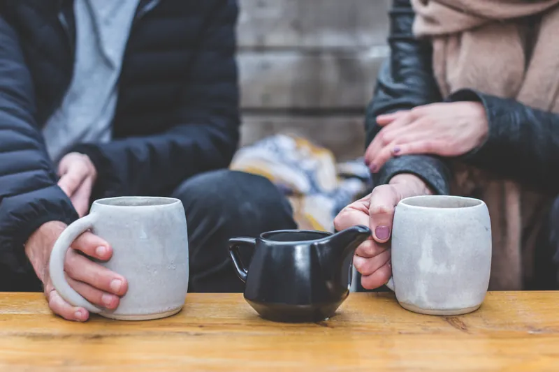 A couple on a date sitting at a table drinking tea