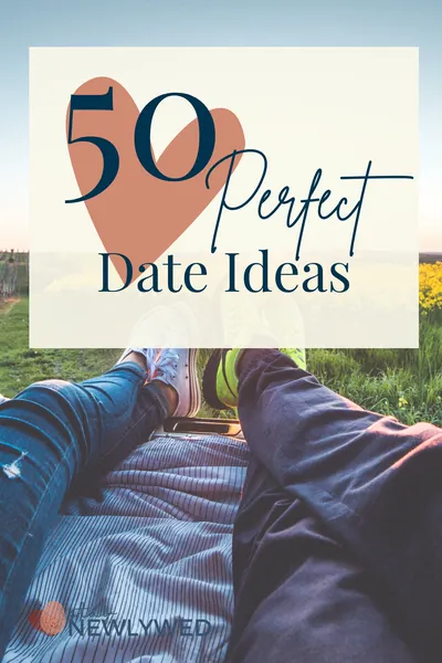 Couples legs hang off the bed of a truck in front of a beautiful country landscape