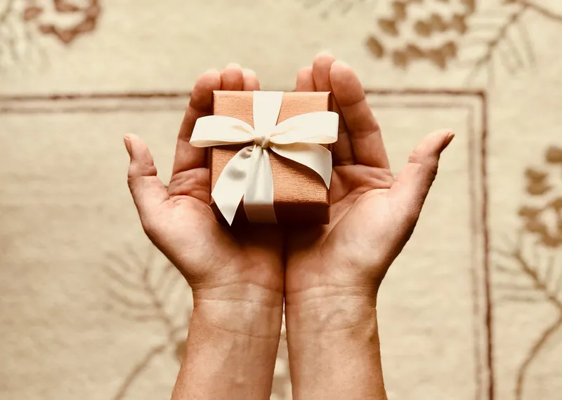 Hands holding a small gift wrapped box