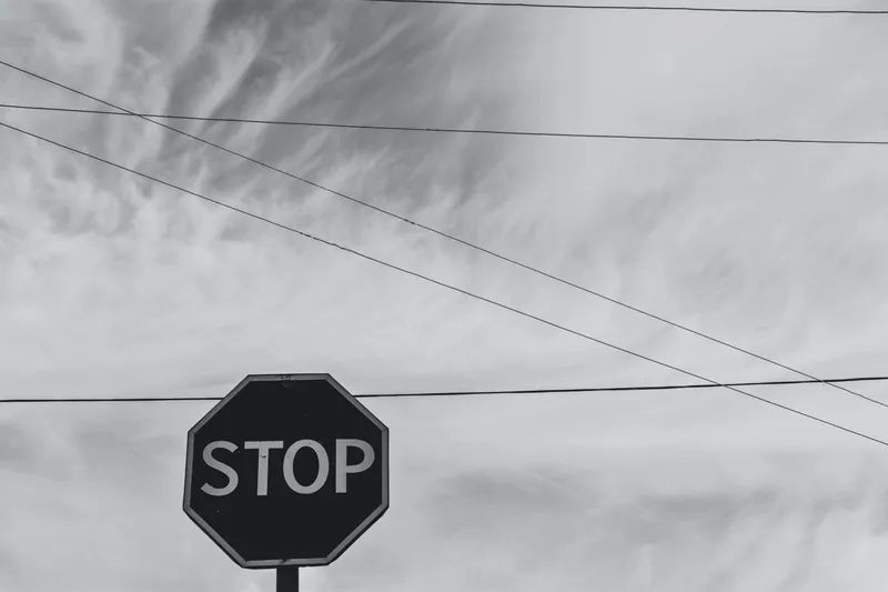 Stop sign in front of a clear sky and power lines