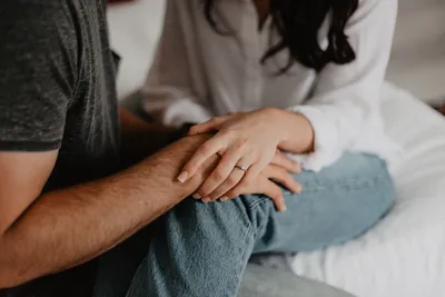 Couple sitting facing each other with hands embraced resting on their knees
